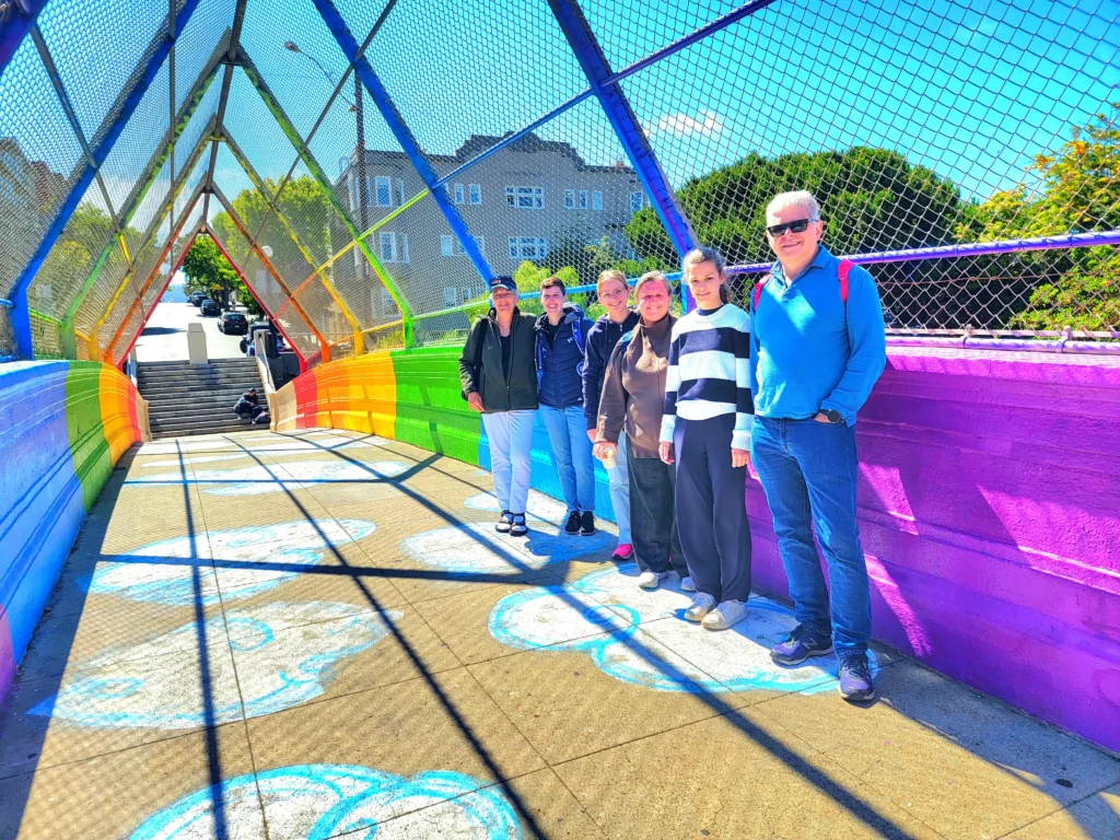 Tour group on a rainbow pedestrian bridge in San Francisco Haight-Ashbury neighborhood